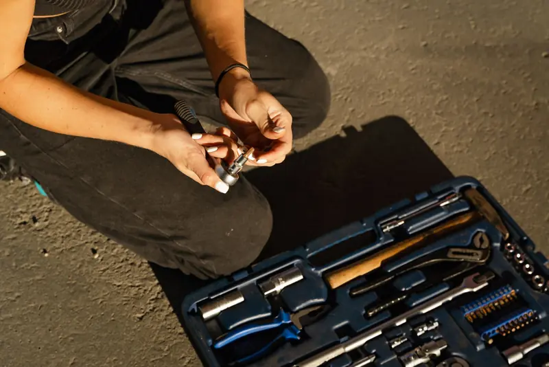 Close-up of a person selecting a tool from a repair kit outdoors. Perfect for DIY or mechanical concepts