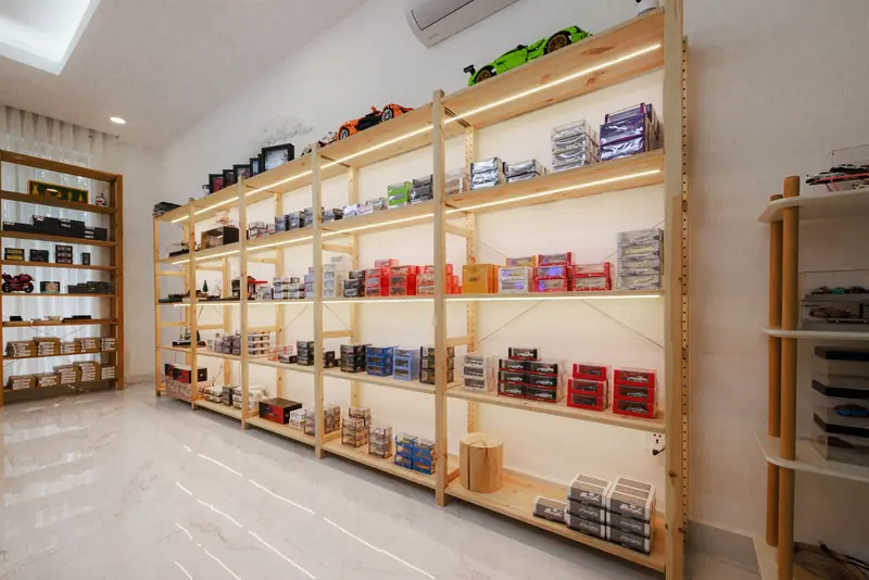 Bright modern display of diecast model cars on wooden shelves in a Phnom Penh store