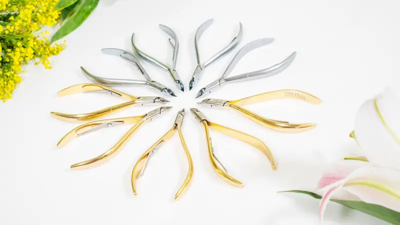 Stylish studio photo of cuticle nippers arranged in a circle with floral accents