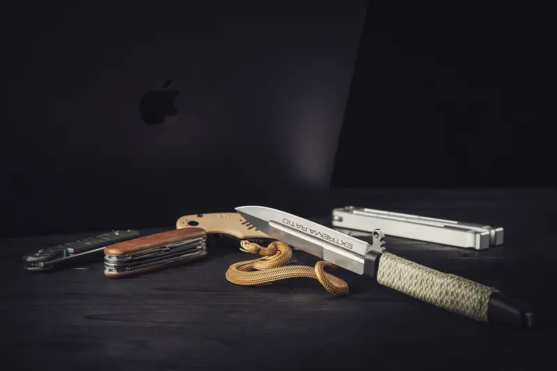 Knife, gadgets, and figurine on a dark modern desk, exuding an urban lifestyle vibe