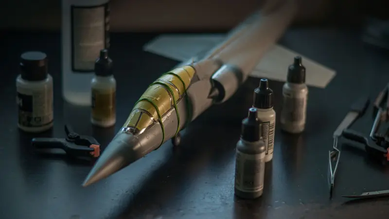Close-up of a scale model F-104 Starfighter with modeling tools and paints on a desk