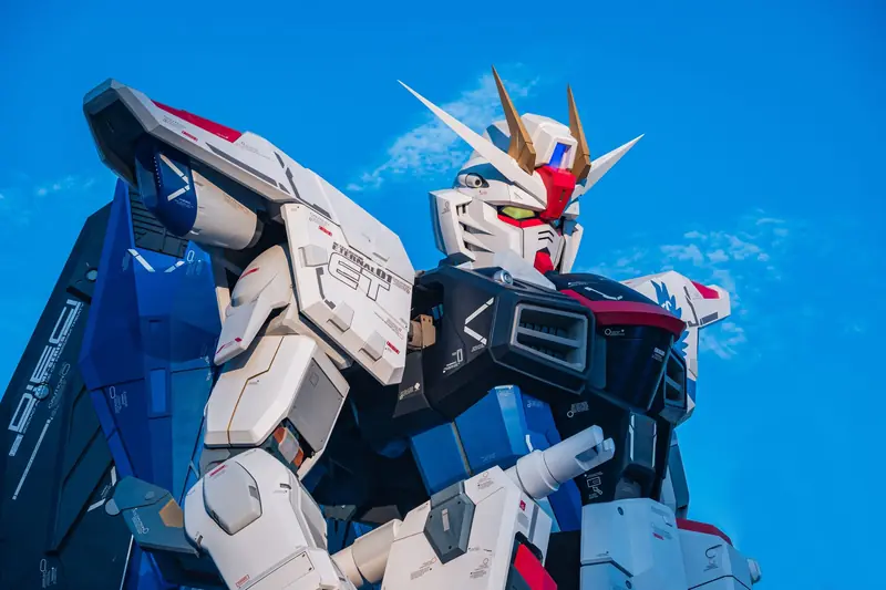 Close-up of a giant Gundam robot statue set against a clear blue sky