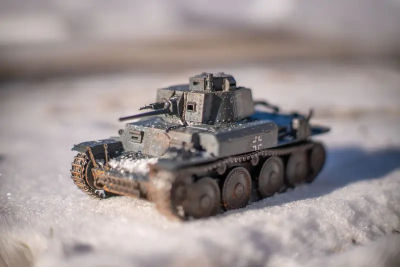 Close-up of a detailed WWII model tank positioned on snowy ground during winter day